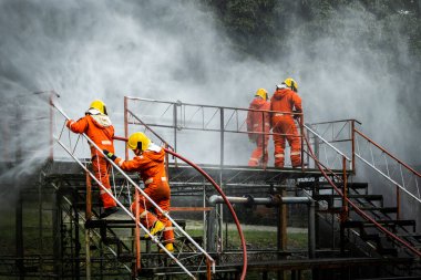 Firefighter Concept. Fireman using water and extinguisher to fighting with fire flame. firefighters fighting a fire with a hose and water during a firefighting training exercise