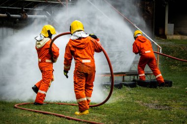 Firefighter Concept. Fireman using water and extinguisher to fighting with fire flame. firefighters fighting a fire with a hose and water during a firefighting training exercise