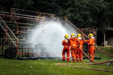 Firefighter Concept. Fireman using water and extinguisher to fighting with fire flame. firefighters fighting a fire with a hose and water during a firefighting training exercise