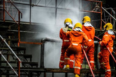 Firefighter Concept. Fireman using water and extinguisher to fighting with fire flame. firefighters fighting a fire with a hose and water during a firefighting training exercise