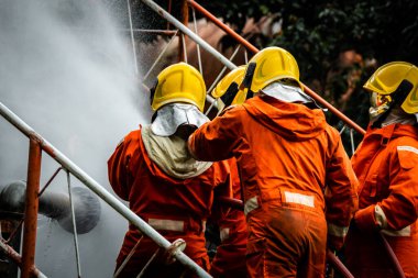 Firefighter Concept. Fireman using water and extinguisher to fighting with fire flame. firefighters fighting a fire with a hose and water during a firefighting training exercise