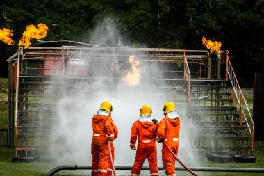 Firefighter Concept. Fireman using water and extinguisher to fighting with fire flame. firefighters fighting a fire with a hose and water during a firefighting training exercise