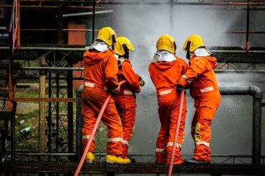 Firefighter Concept. Fireman using water and extinguisher to fighting with fire flame. firefighters fighting a fire with a hose and water during a firefighting training exercise