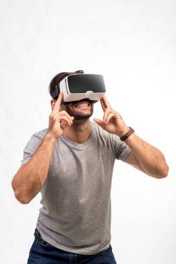 VR kulaklıklı adam. İnternet oyunu için VR gözlük kullanan bir adam. Sanal gerçeklik kulaklığı kullanan yakışıklı bir adam. İnsan sanal gerçekliği VR kulaklığı ile tecrübe eder ve elleriyle bir şeye dokunur..