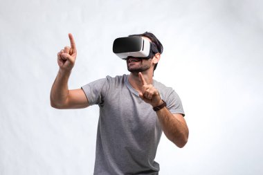 VR kulaklıklı adam. İnternet oyunu için VR gözlük kullanan bir adam. Sanal gerçeklik kulaklığı kullanan yakışıklı bir adam. İnsan sanal gerçekliği VR kulaklığı ile tecrübe eder ve elleriyle bir şeye dokunur..