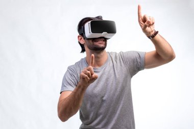 VR kulaklıklı adam. İnternet oyunu için VR gözlük kullanan bir adam. Sanal gerçeklik kulaklığı kullanan yakışıklı bir adam. İnsan sanal gerçekliği VR kulaklığı ile tecrübe eder ve elleriyle bir şeye dokunur..