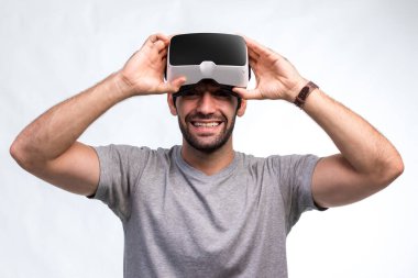 VR kulaklıklı adam. İnternet oyunu için VR gözlük kullanan bir adam. Sanal gerçeklik kulaklığı kullanan yakışıklı bir adam. İnsan sanal gerçekliği VR kulaklığı ile tecrübe eder ve elleriyle bir şeye dokunur..