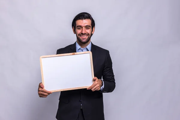 Businessman holding chalk board on white background. Handsome businessman holding black board. Handsome man holding small framed blackboard