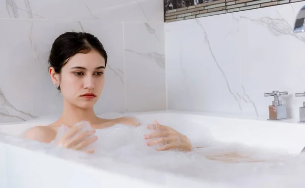 松懈的女人躺在浴缸里 享受的概念 坐在肥皂泡里 躺在充满泡沫的浴缸里玩乐的女人 美丽的女人在浴室的浴缸里尽情享受 — 图库照片