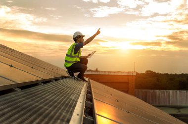 Engineer working setup Solar panel at the roof top. Engineer or worker work on solar panels or solar cells on the roof of business building