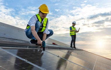 Engineer working setup Solar panel at the roof top. Engineer or worker work on solar panels or solar cells on the roof of business building
