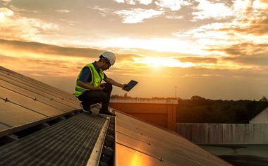 Engineer working setup Solar panel at the roof top. Engineer or worker work on solar panels or solar cells on the roof of business building