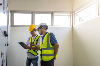 Kontrol odasında çalışan elektrik mühendisi. Elektrik mühendisi kontrol odasındaki güç dağıtım dolabını kontrol ediyor.