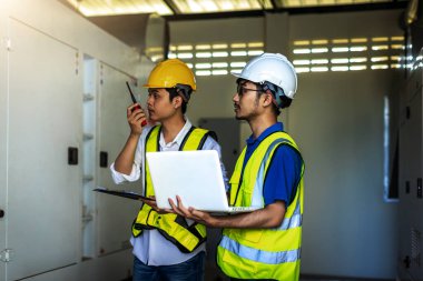 Electrical engineer working in control room. Electrical engineer man checking Power Distribution Cabinet in the control room