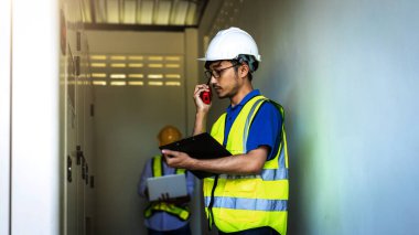 Kontrol odasında çalışan elektrik mühendisi. Elektrik mühendisi kontrol odasındaki güç dağıtım dolabını kontrol ediyor.