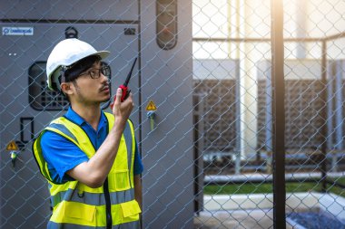 Kontrol odasında çalışan elektrik mühendisi. Elektrik mühendisi kontrol odasındaki güç dağıtım dolabını kontrol ediyor.