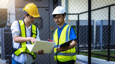 Kontrol odasında çalışan elektrik mühendisi. Elektrik mühendisi kontrol odasındaki güç dağıtım dolabını kontrol ediyor.