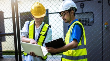 Kontrol odasında çalışan elektrik mühendisi. Elektrik mühendisi kontrol odasındaki güç dağıtım dolabını kontrol ediyor.