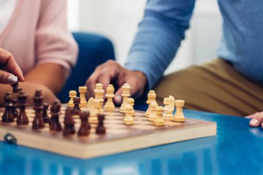 Satranç tahtası oyunu oynayan kişi. Yaşlı adam satranç oynuyor. Başarı oyununda satranç oynayan kıdemli adamın eli. Strateji, yönetim ya da liderlik kavramı. İş stratejisi ve taktik kavramı