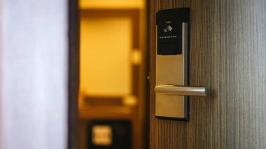 Oteldeki akıllı kart kapısı kilit sistemi. Ahşap kapıdaki otel elektronik kilidi. Elektronik kartı olan giriş kapısı. Otelin korunması için dijital kapı kilitleme sistemleri