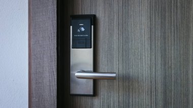 Oteldeki akıllı kart kapısı kilit sistemi. Ahşap kapıdaki otel elektronik kilidi. Elektronik kartı olan giriş kapısı. Otelin korunması için dijital kapı kilitleme sistemleri