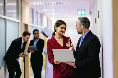 Çeşitli arkadaş ortaklar modern ofis koridorlarında yürümekten bahseder. Ofiste yürüyen ve konuşan kendine güvenen iş ortakları. Profesyonel iş adamları yürüyor ve konuşuyor.