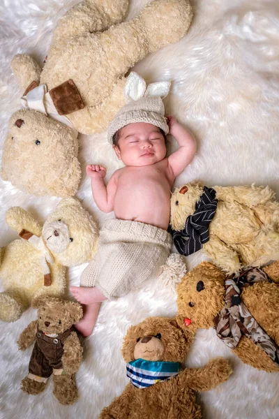 Bebé recién nacido de dos semanas durmiendo en un oso de peluche