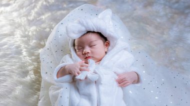 Yeni doğan uyuyor. Yeni doğmuş bebekler yatakta uyur. Yeni doğan bebeklerin yatakta güzel bir uykusu var. Sevimli ikiz bebek evde çekim yapıyor. bebek ve ailenin moda imajı. 