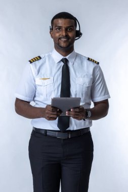 Gülümseyen uçak pilotu. Profesyonel kendine güvenen pilot uzmanı. Uçak pilotu üniforması giyen yakışıklı bir adam. Havacıların beyaz arka planda portresi. Beyaz arka planda duran bir havayolu kaptanı