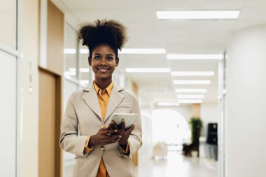 Kadının elinde dizüstü bilgisayar tableti ve kalem var. Modern ofiste ayağa kalk. Kadınlar kendilerine güvenen yeni şirkete liderlik ediyorlar. Profesyonel kendine güvenen iş uzmanı.