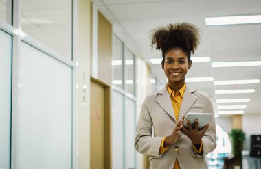 Kadının elinde dizüstü bilgisayar tableti ve kalem var. Modern ofiste ayağa kalk. Kadınlar kendilerine güvenen yeni şirkete liderlik ediyorlar. Profesyonel kendine güvenen iş uzmanı.