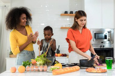 Pride LGBT Family at the kitchen Happy face. Preparing family dinner at home. Happy smiling family having fun cooking at kitchen together. Family lifestyle. Happy together cooking on kitchen.	