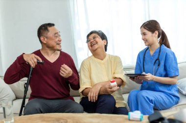 Bakıcı hemşire evde kanepede oturan kıdemli bir hastayla ilgilenir. Hemşire yaşlılara yardım ediyor