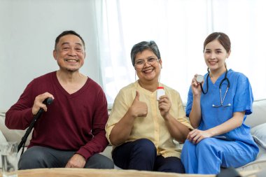 Bakıcı hemşire evde kanepede oturan kıdemli bir hastayla ilgilenir. Hemşire yaşlılara yardım ediyor