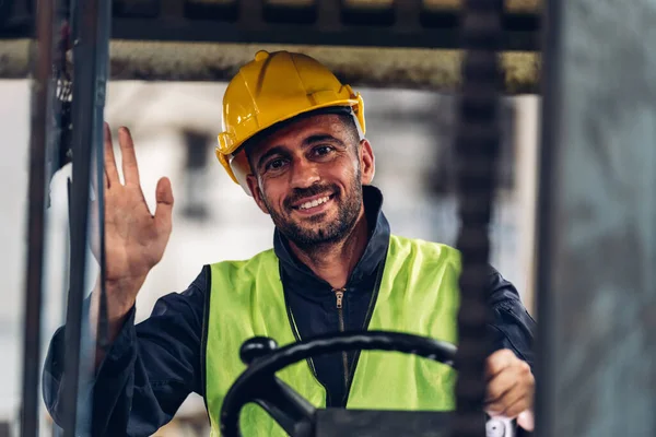 stock image Man worker at forklift driver happy working in industry factory logistic ship. Man forklift driver in warehouse area.	Forklift driver sitting in vehicle in warehouse