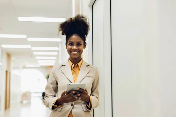 Woman holds a laptop tablet and a pen. Stand up in the modern office. Women leader the new company self-confident. Professional Confident business expert.