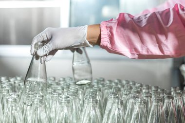 Worker Checking quality or checking stock of glass bottle in beverage factory. Worker QC working in a drink water factory 