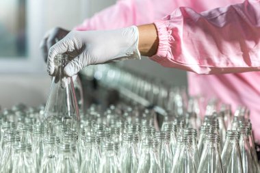 Worker Checking quality or checking stock of glass bottle in beverage factory. Worker QC working in a drink water factory 