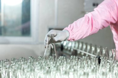 Worker Checking quality or checking stock of glass bottle in beverage factory. Worker QC working in a drink water factory 