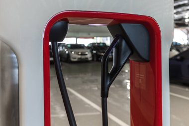 Yenilenebilir Enerji Konsepti. Elektrikli araba şarj istasyonu. Otoparktaki hibrit araba elektrik şarj istasyonu. Elektrikli araba park ve şarj istasyonunda şarj oluyor. Elektrik prizi. Ulaşım EV