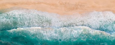 Metnin için fotokopi alanı olan turkuaz suyla çarpıcı güzellikteki deniz manzaralı bir kumsalın insansız hava aracı görüntüsü. Turkuaz suyla güzel bir kumsal, insansız hava aracı görüntüsü.