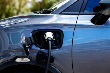 Elektrikli araba şarj istasyonu. Otoparktaki hibrit araba elektrik şarj istasyonu. Elektrikli araba park ve şarj istasyonunda şarj oluyor. Elektrik prizi. Ulaşım EV