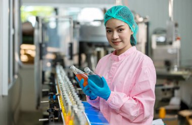 Yiyecek fabrikası. Fabrika müfettişi üretimi kontrol ediyor. Denetmen ya da işçi içecek fabrikasındaki ürünleri kontrol ediyor ya da kontrol ediyor. Bir içme suyu fabrikasında çalışan işçi QC 