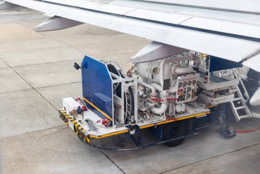 Aircraft refueling by high pressure fuel supply truck. Refueling operation of large widebody passenger aircraft standing on airport's parking place . Refueling of the airplane before flight.	
