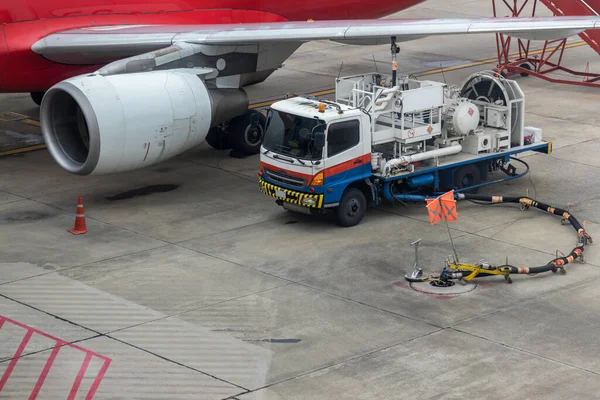 Aircraft refueling by high pressure fuel supply truck. Refueling operation of large widebody passenger aircraft standing on airport's parking place . Refueling of the airplane before flight.	