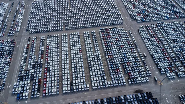 Aerial view car waiting for export shipping to worldwide. Aerial view new car lined up in the port for import and export business logistic. Storage of modern cars on parking.