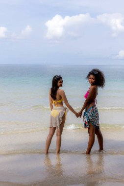 Yaz tatilinde kumsalda bir kadın. Tropik bir plajda güneşlenen güzel bir kız. Kumlu sahilde bikinili bir kadın turist. Cennetteki tropik plajda seksi bikinili kadın.
