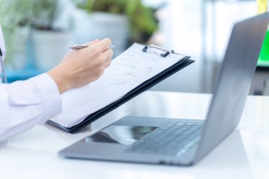 Bilim adamı ya da eczacı bilimsel laboratuvar deneylerini kontrol etmek için listeyi tutuyor. Bilim adamı, laboratuvar testinde yazma ve kontrol için kontrol listesi tutuyor. Kadının elinde bir piliç listesi ve kalem var.. 