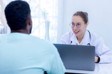 Doktor listeyi tutuyor ve hastanedeki hasta adamla konuşuyor. Doktor, erkek hastayı hastane odasında muayene ediyor..