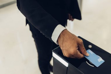 İşadamı ofis binasında otomatik geçit makinesini açmak için kart kullanıyor. Erkek, ofis binasında otomatik geçit makinesini açmak için akıllı kart kullanıyor. Çalışma rutini kavramı.